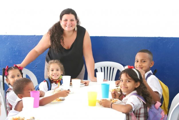 Imagen de la directora de cobertura al lado de niños